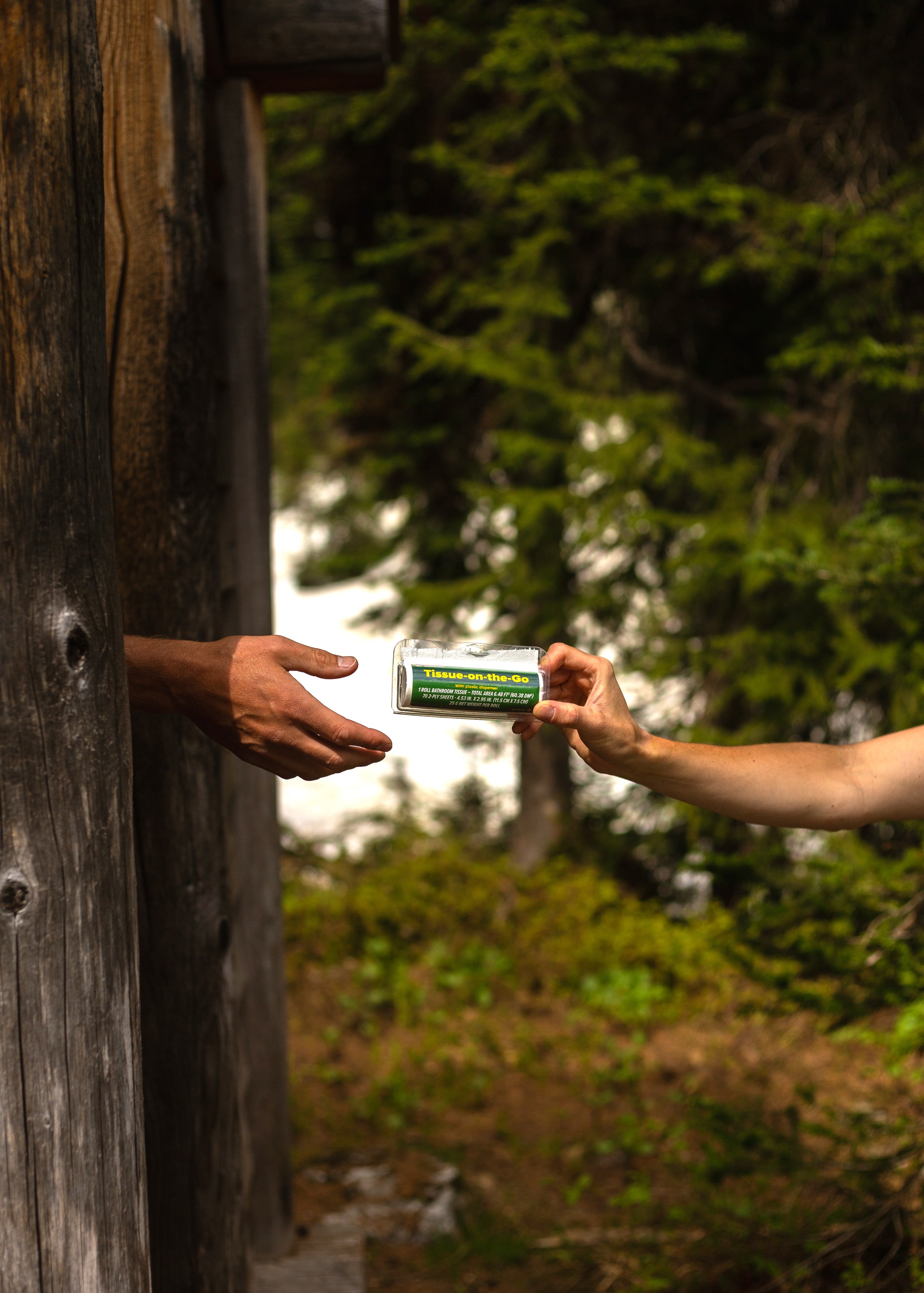 A person handing another person toilet tissue